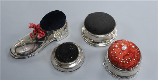 An Edwardian silver pin cushion formed as a gentlemans shoe with wooden sole, Blanckansee & Son Ltd and three circular pin cushions